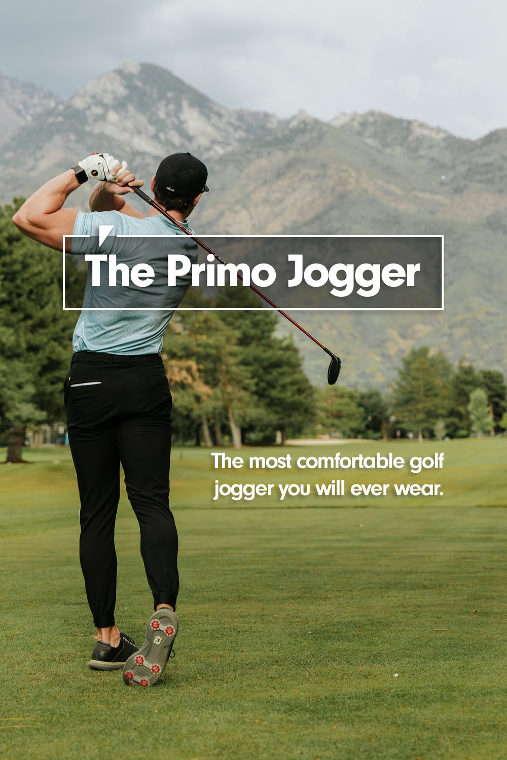 Male model is wearing black primo joggers and a green banana blade collar photo.  He is hold his finish with a 3 wood hitting a tee shot down a fairway looking into the beautiful Utah mountains